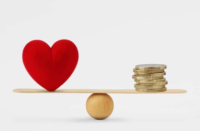 Heart and money on balance scale - Order of priority in life among love and money