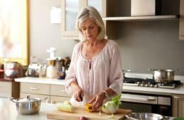 older woman in kitchen preparing healthy meal